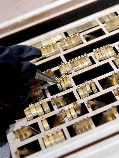 Omega Technician selecting the letters to emboss a Nato Strap