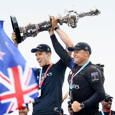 Peter Burling and Glenn Ashby of Emirates Team New Zealand lift the America’s Cup trophy in Bermuda