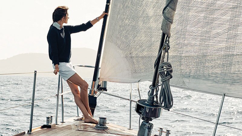 亞歷桑德拉‧安布羅休悠閒地坐在遊艇船頭的安全圍欄上，凝望著地中海。